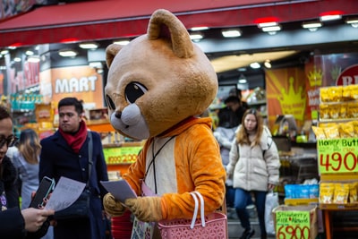 Handing out leaflets mascot in the daytime
